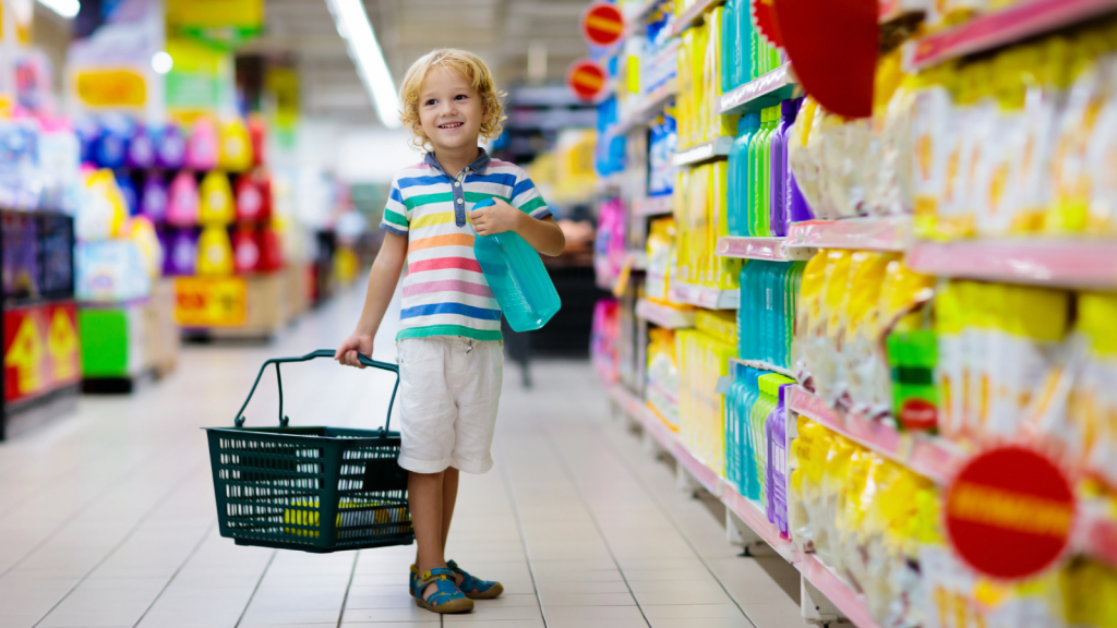 Child in supermarket buying fruit and juice.