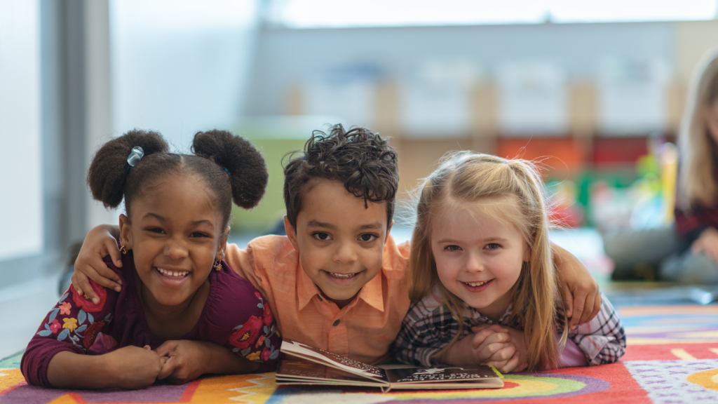 Children reading and facing camera smiling -